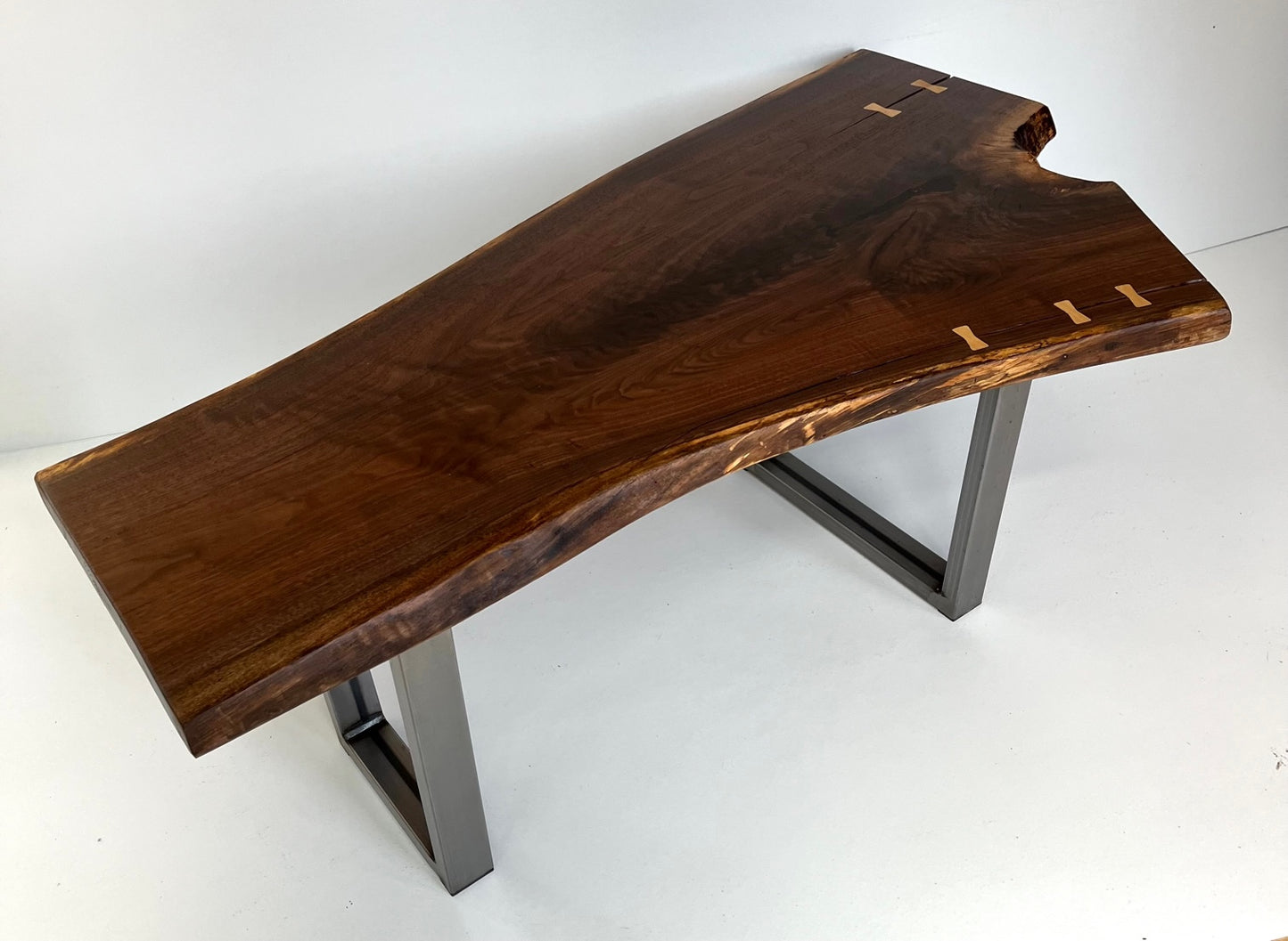 Live edge coffee table-walnut with maple butterfly inlay side angle view